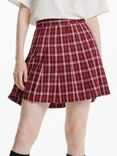 A woman wears a red plaid skirt.